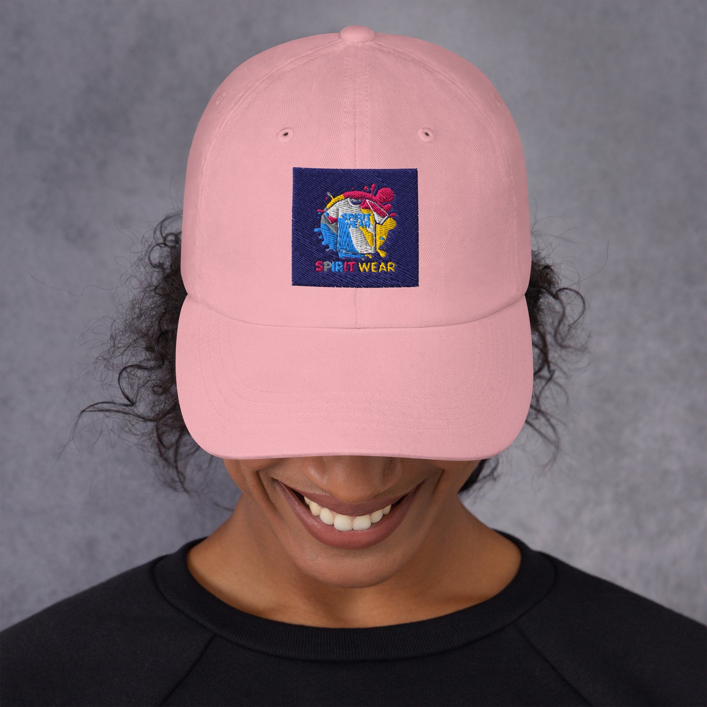 Pink Christian ball cap by Spirit Wear with colorful embroidered logo worn by smiling person