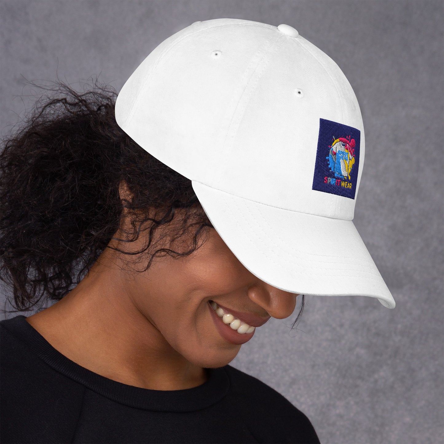 White Christian ball cap by Spirit Wear with colorful embroidered logo on front worn by smiling woman