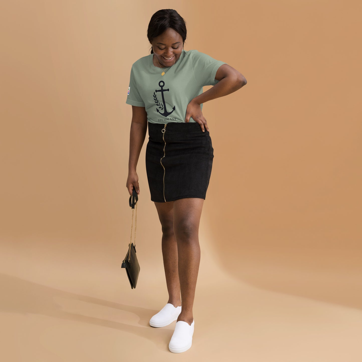 Woman wearing Spirit Wear mint green Christian anchor shirt for men and women paired with black skirt and white slip on shoes