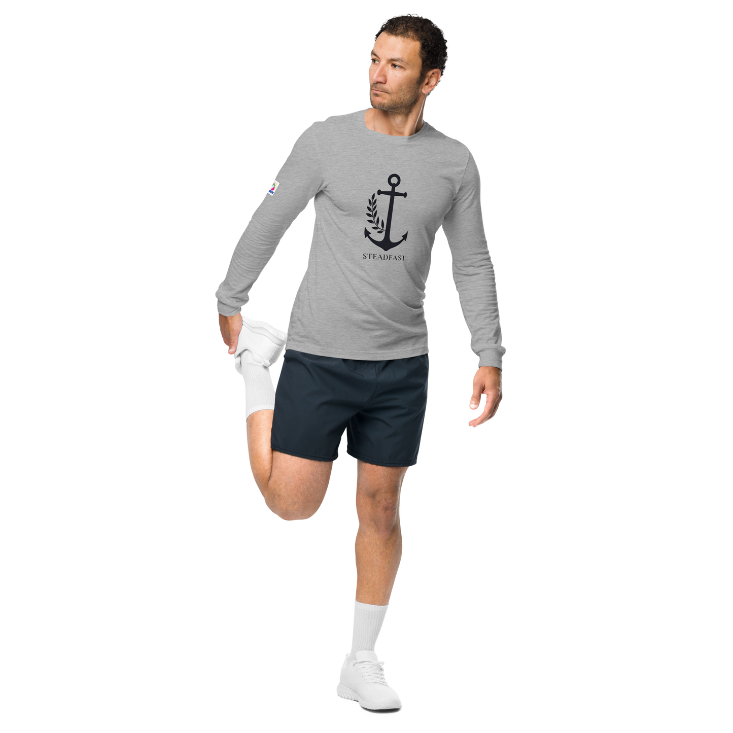 Spirit Wear model stretching in gray inspirational long sleeve t-shirt with anchor logo wearing navy shorts and white sneakers