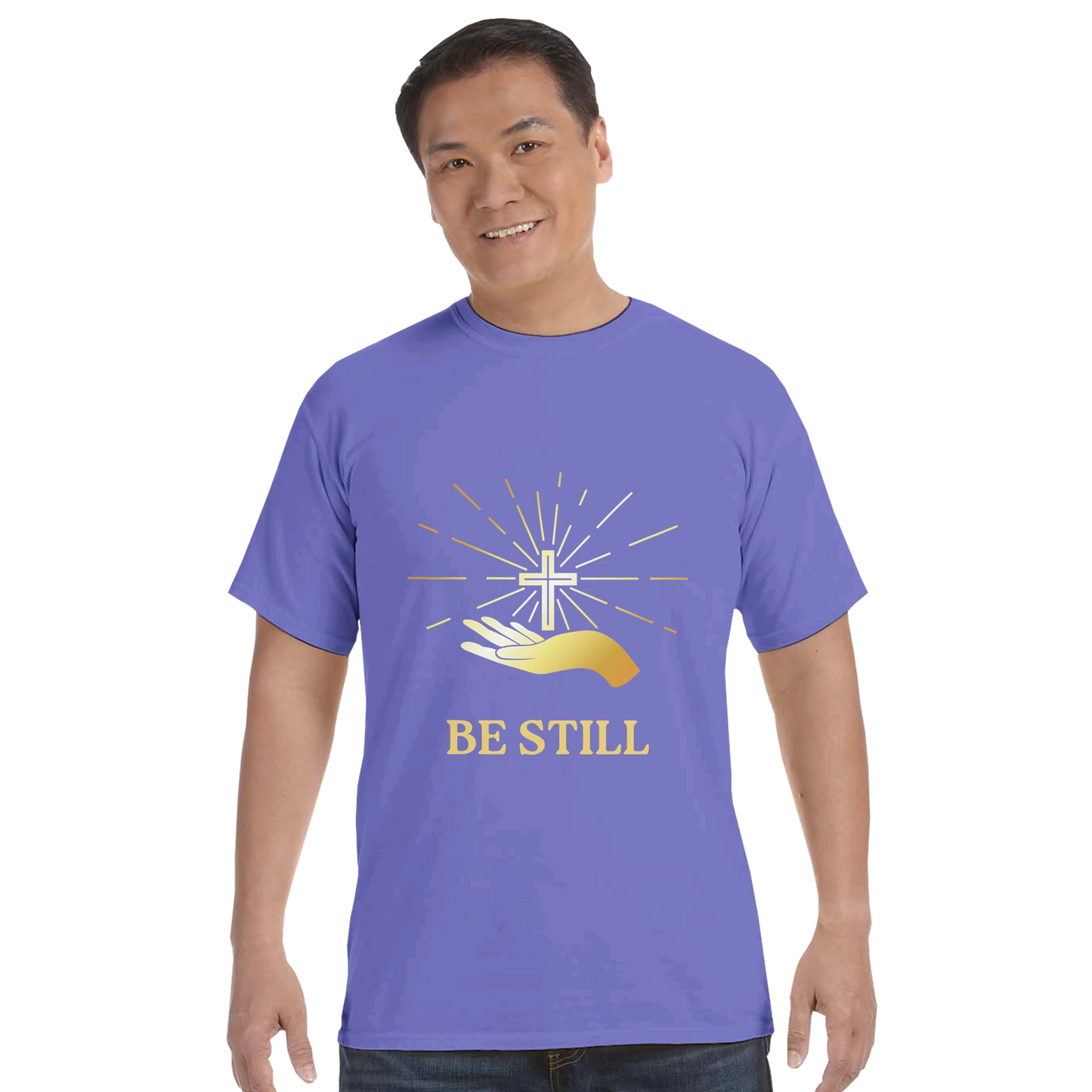 Christian graphic t-shirt featuring a cross and the text Be Still on a purple background