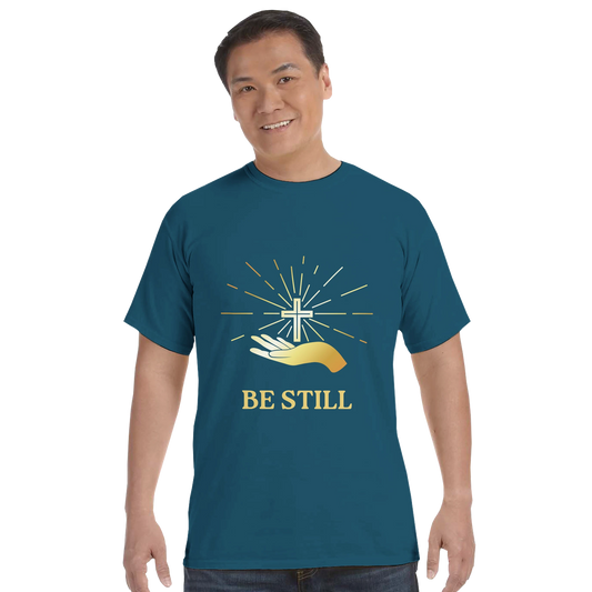 Teal Christian graphic t-shirt featuring a cross and hands with the message Be Still