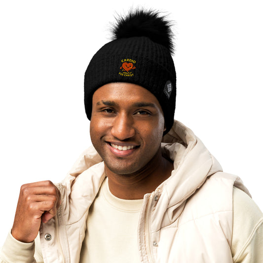 Spirit Wear black Christian winter beanie with pom-pom and cardio for Christ logo on a smiling man