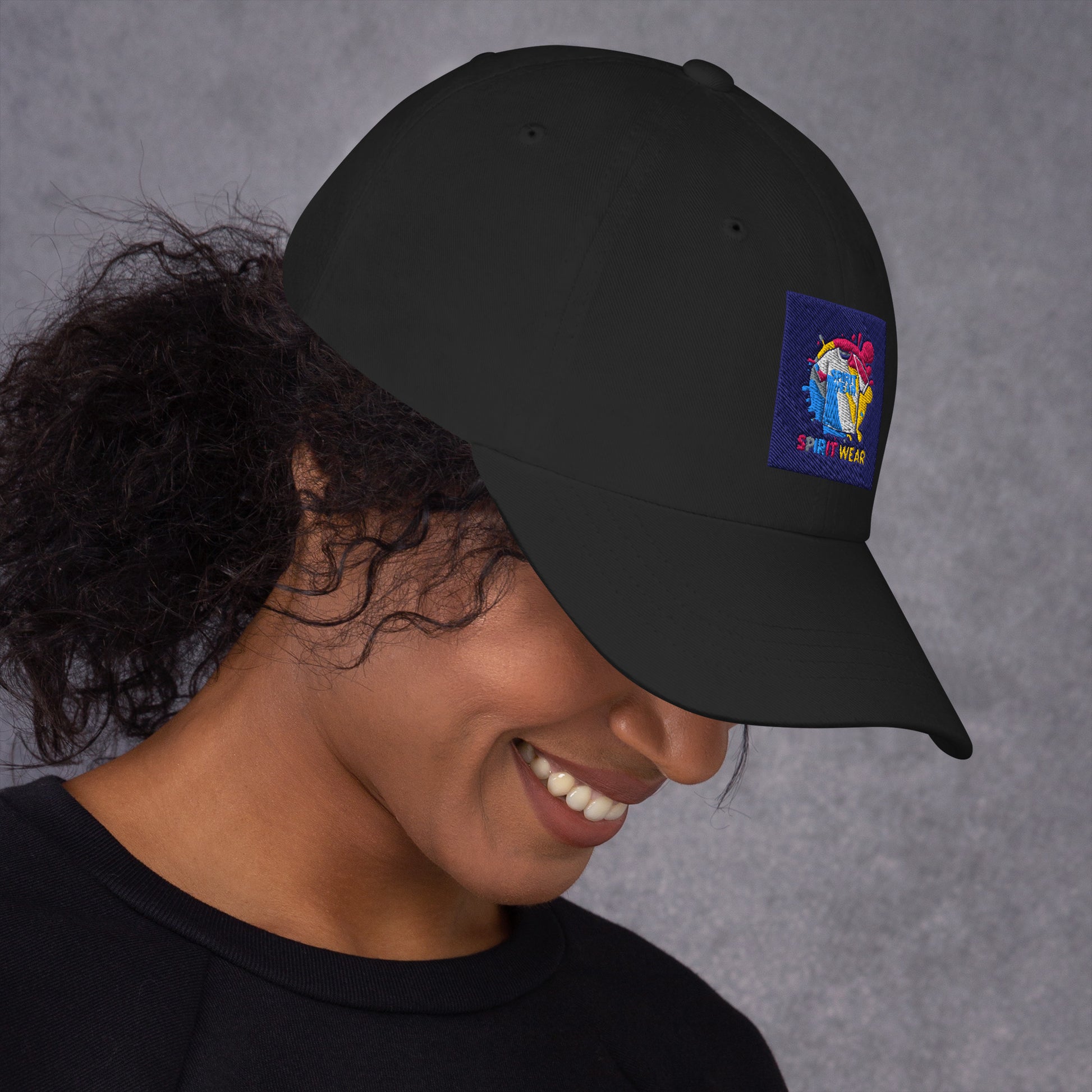 Black Christian ball cap by Spirit Wear with colorful embroidered logo worn by smiling woman