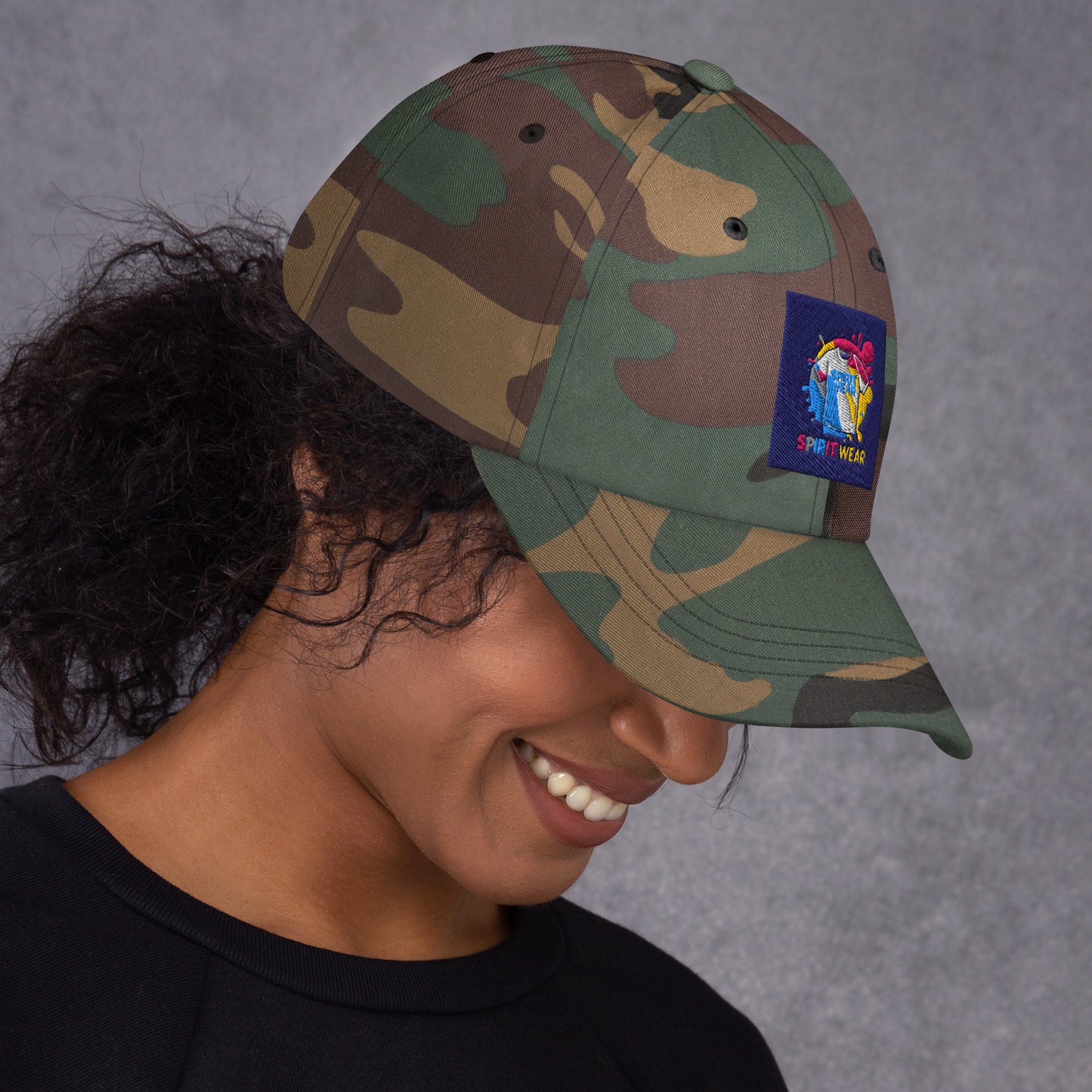Spirit Wear camo Christian ball cap with colorful logo patch worn by smiling woman