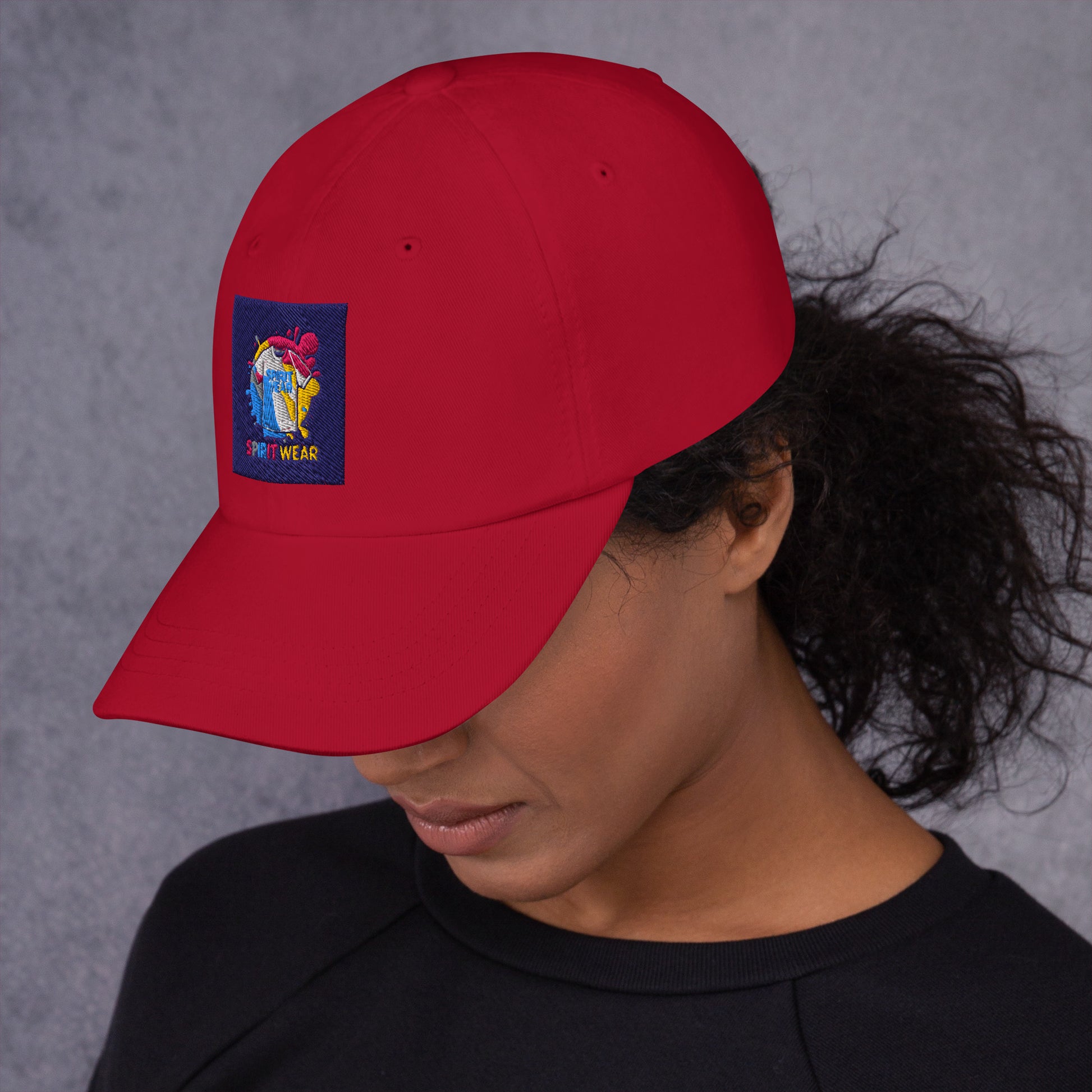 Red Christian ball cap from Spirit Wear with colorful religious patch worn by woman