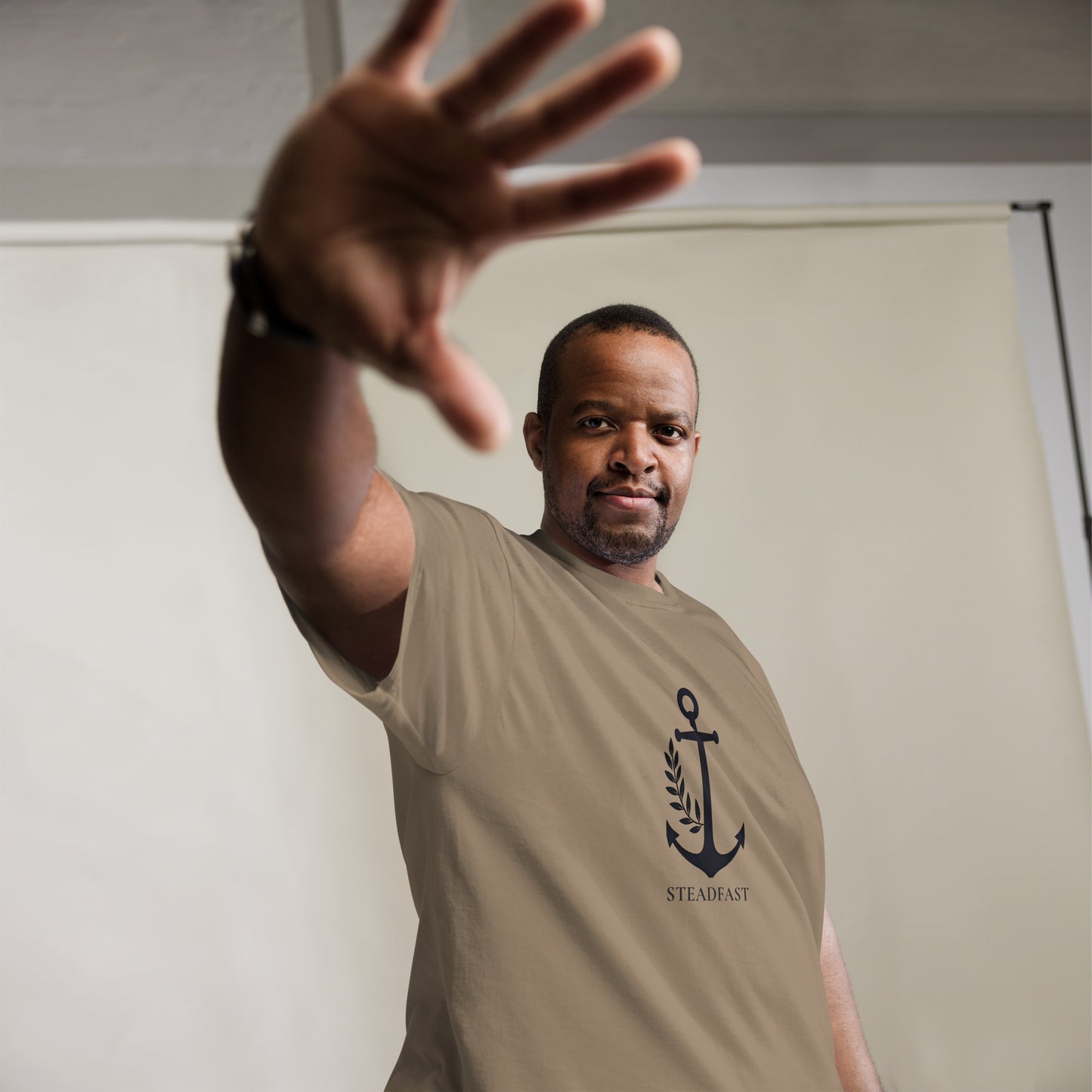 Spirit Wear Christian t-shirt withchor design tan shirt on man with black anchor graphic and STEADFAST text