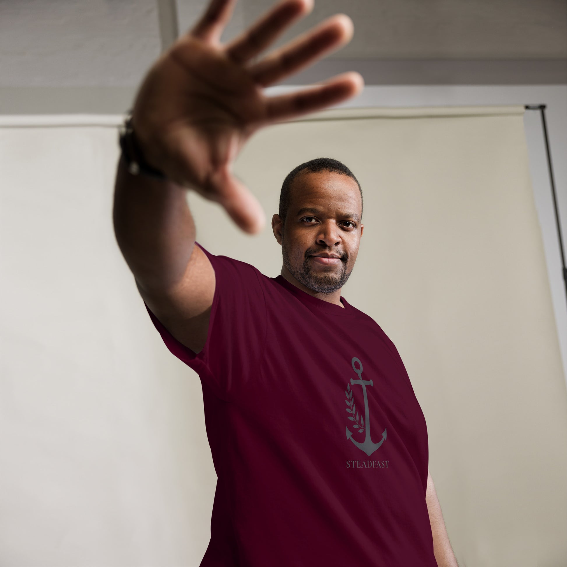 Spirit Wear male model wearing maroon Christian t-shirt withchor design anchor motif and steadfast text