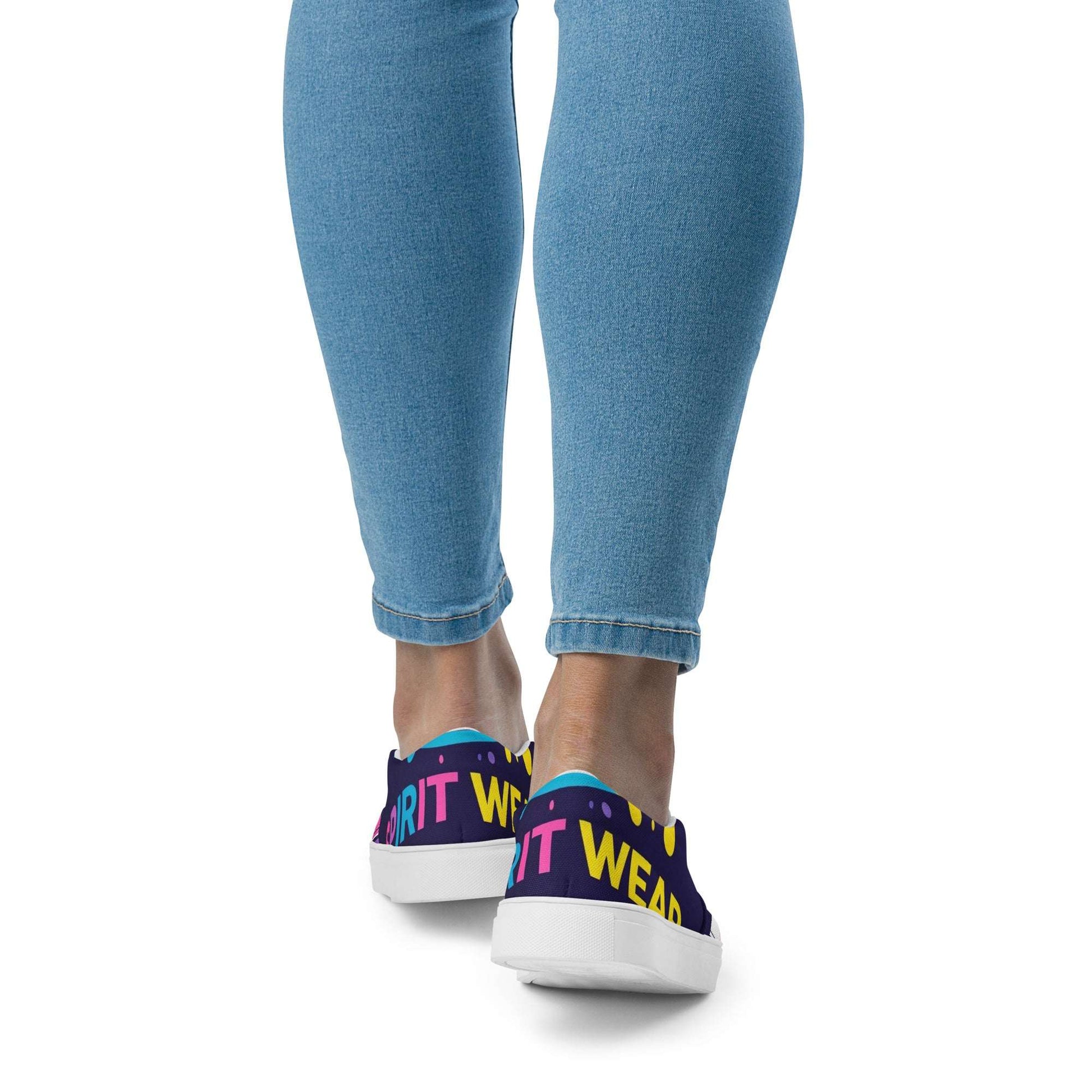 Spirit Wear women's slip-on canvas shoes in colorful design with white soles worn with blue jeans